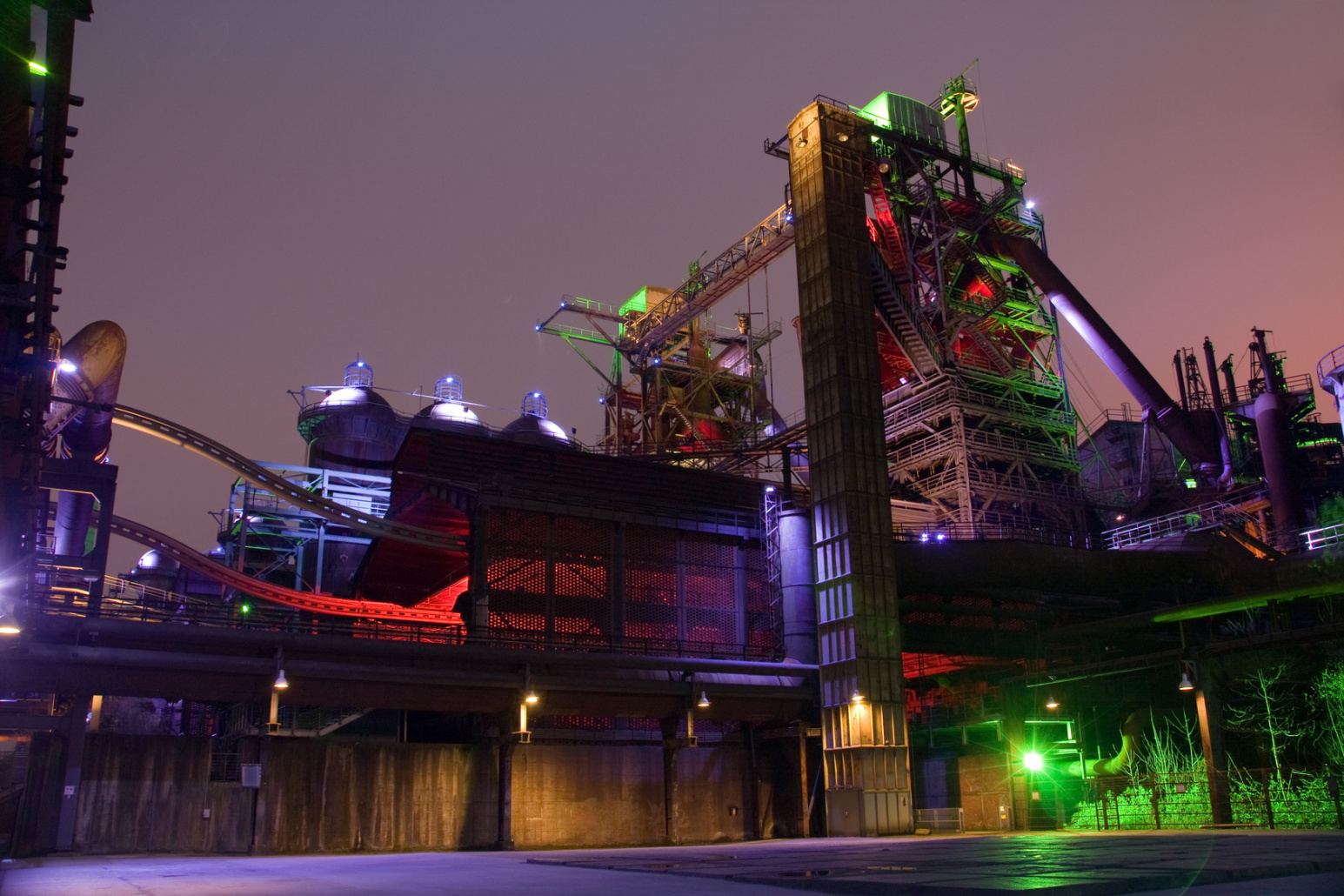 Ehemaliges Thyssen-Hüttenwerk im Landschaftspark Duisburg-Nord, bunt illuminiert bei Nacht; Kurtz Wirtschaftsdetektei Duisburg